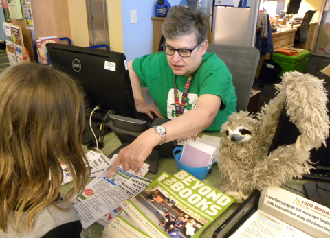 Child getting help at a library service desk